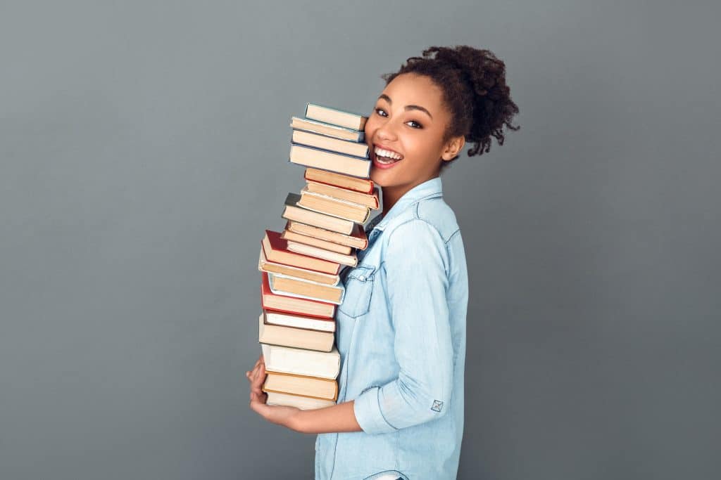 Woman carrying stack of books. Book Sale.