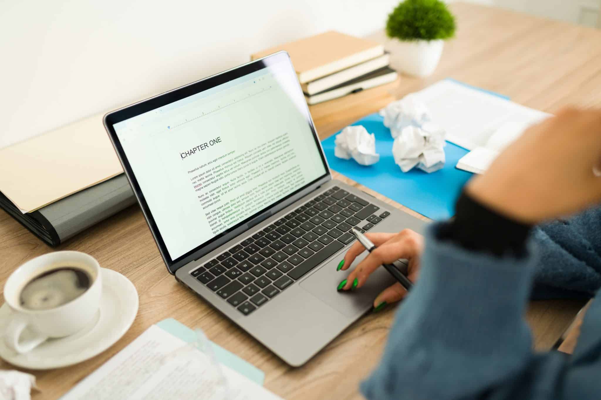 Closeup of a young author writing chapter one of new book using a laptop